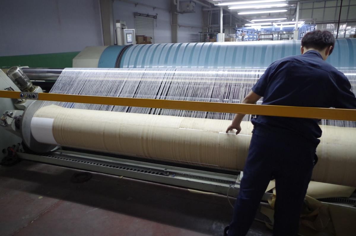 Operator checking mesh on the loom